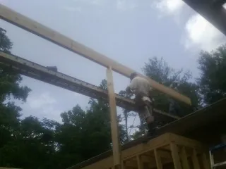 Carpenter setting a ridge beam over a new addition frame — Ice Dam Removal by Roofing Brothers in Westerly