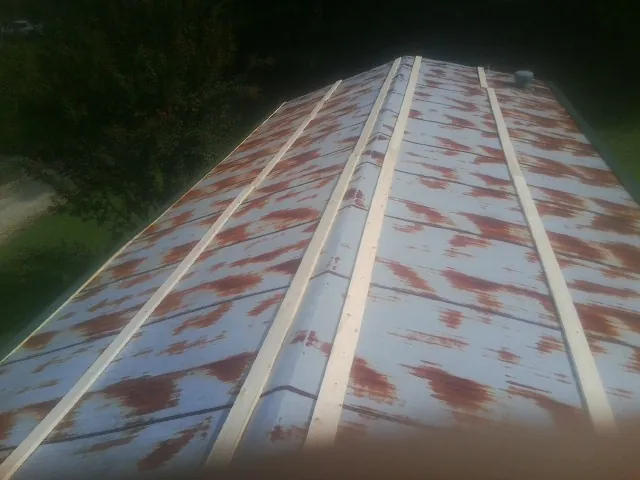 Rusted metal roof panels with new wood purlins before replacement — Storm Damage Roof Repair in Westerly by Roofing Brothers