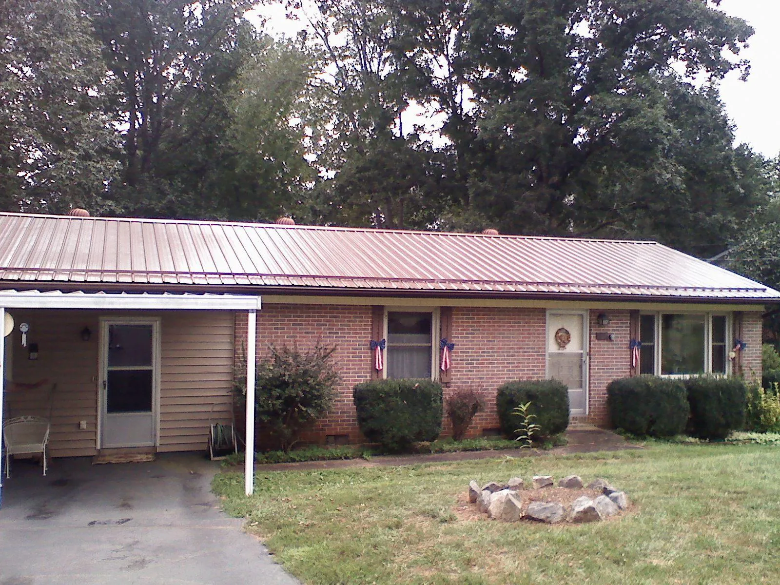 Bronze metal roof and carport on a brick ranch home — Roof Repair work by our crew in Westerly